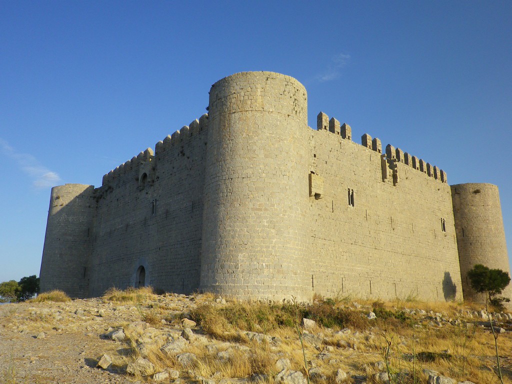 Una de les quatre torres cilíndriques amb  murs i merlets.